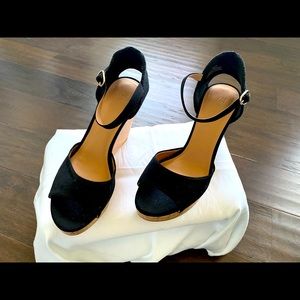 Woman’s black wedges with ankle strap.